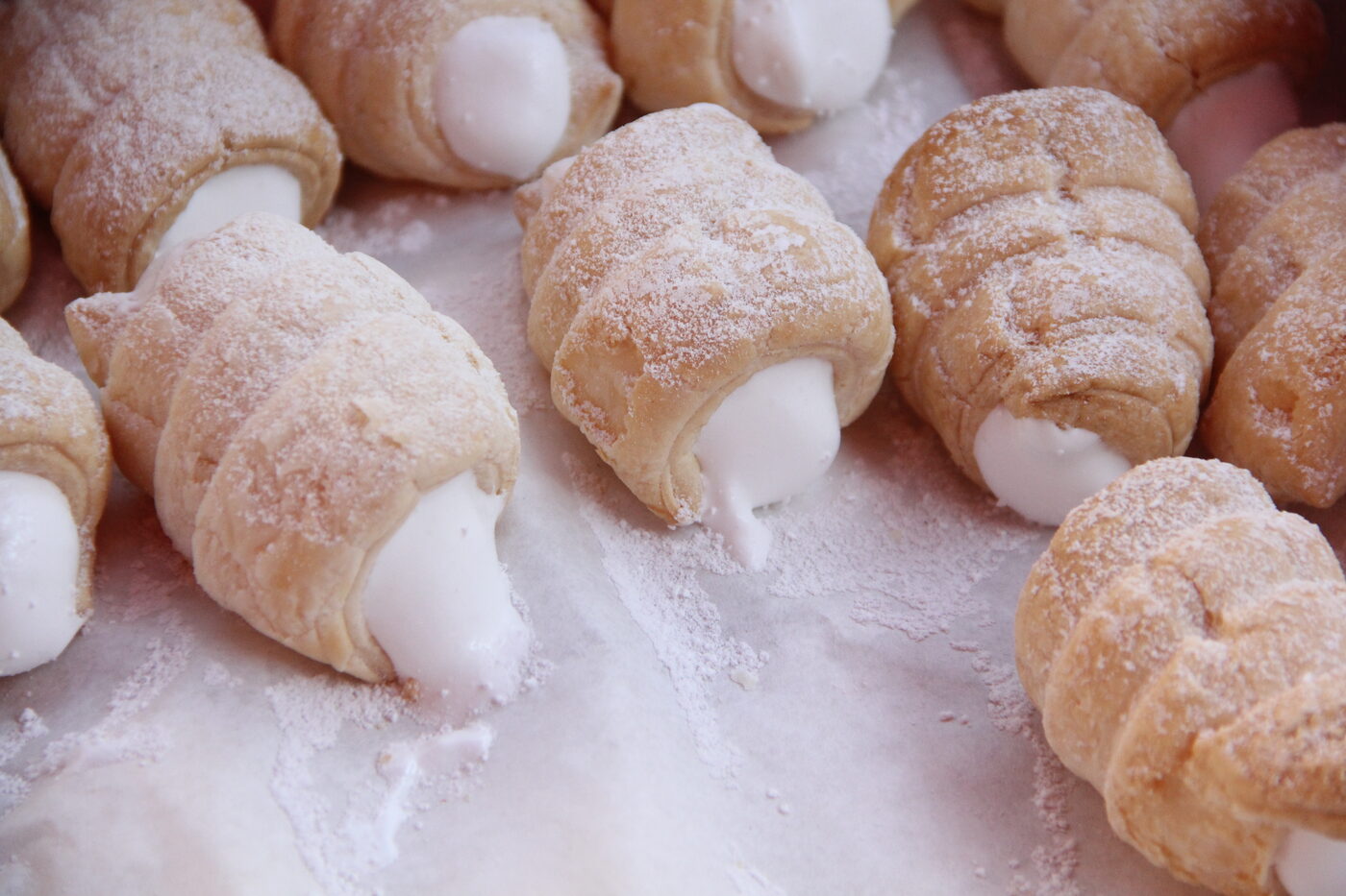Frische Schaumrollen mit Cremefüllung, bestäubt mit Staubzucker